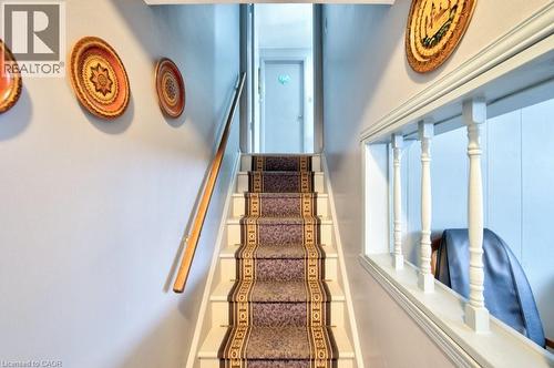 Carpeted staircase featuring a patterned runner and a wooden handrail - 34 Westwood Crescent, Kitchener, ON - Indoor Photo Showing Other Room