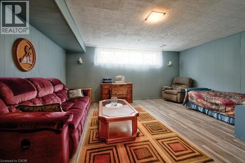 Spacious room featuring wood-finish flooring and light blue vertical plank paneling - 34 Westwood Crescent, Kitchener, ON - Indoor