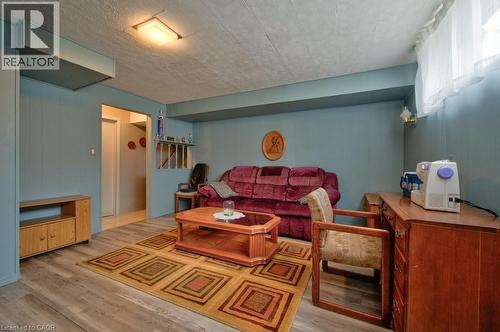 Recreation space featuring wood-finish flooring, light blue paneling, and a drop ceiling with recessed lighting - 34 Westwood Crescent, Kitchener, ON - Indoor
