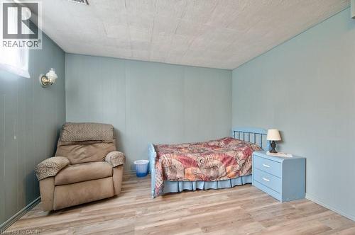 Room featuring light blue paneling, wood-finish flooring, and a drop ceiling - 34 Westwood Crescent, Kitchener, ON - Indoor Photo Showing Bedroom