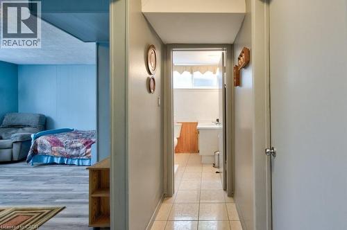Hallway featuring neutral painted walls and a tiled floor, leading to a bathroom with a window and a vanity - 34 Westwood Crescent, Kitchener, ON - Indoor Photo Showing Other Room