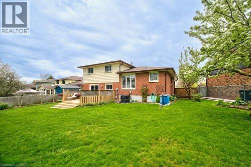 Expansive green lawn with a multi-level wood deck featuring a pergola - 34 Westwood Crescent, Kitchener, ON - Outdoor