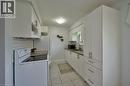 Contemporary kitchen featuring white shaker-style cabinetry, a white subway tile backsplash, and a built-in range - 34 Westwood Crescent, Kitchener, ON  - Indoor Photo Showing Laundry Room 