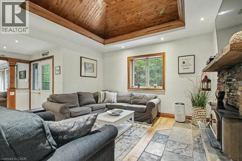 Living area featuring a wood-paneled tray ceiling, recessed lighting, and a stone-clad fireplace - 1333 Hidden Valley Road, Burlington, ON - Indoor Photo Showing Living Room