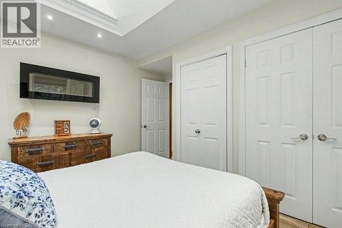 Recessed lighting illuminates a tray ceiling and a wall-mounted electric fireplace - 1333 Hidden Valley Road, Burlington, ON - Indoor Photo Showing Bedroom