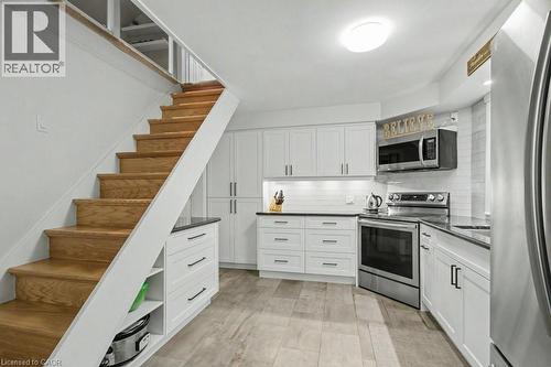 Modern kitchen featuring white shaker cabinetry with dark hardware, dark countertops, and a white subway tile backsplash - 1333 Hidden Valley Road, Burlington, ON - Indoor Photo Showing Kitchen