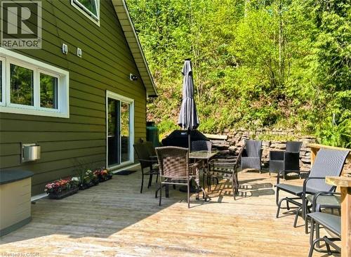 Expansive exterior deck featuring natural wood flooring and a stacked stone retaining wall - 1333 Hidden Valley Road, Burlington, ON - Outdoor With Deck Patio Veranda With Exterior