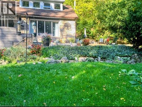 Stone veneer exterior with a full-width window, dormer windows, and tiered landscaping - 1333 Hidden Valley Road, Burlington, ON - Outdoor