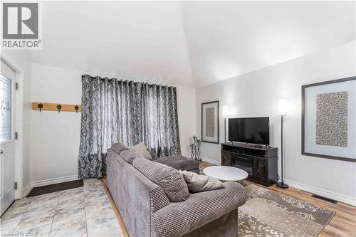 Living area featuring a vaulted ceiling and a wood-finish floor - 74 Province Street N, Hamilton, ON - Indoor