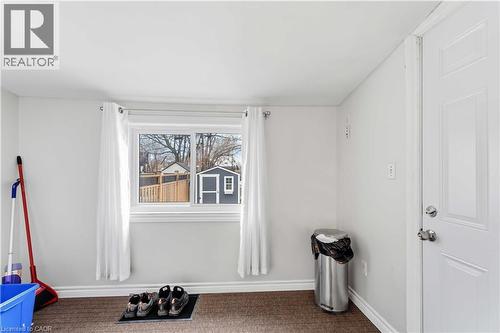 Bright room featuring a window with white trim, light-colored walls, baseboard molding, and carpet flooring - 74 Province Street N, Hamilton, ON - Indoor Photo Showing Other Room