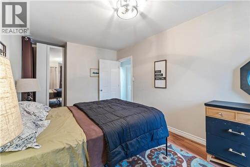 Hardwood-style flooring complemented by light-toned wall finishes - 74 Province Street N, Hamilton, ON - Indoor Photo Showing Bedroom