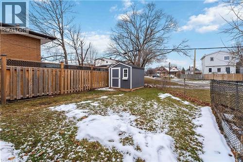 Backyard featuring a gray storage shed with white trim, a wood privacy fence with lattice top, and a chain-link fence - 74 Province Street N, Hamilton, ON - Outdoor