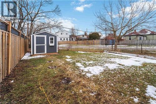 Spacious backyard featuring a storage shed, wood privacy fencing, and a chain-link fence - 74 Province Street N, Hamilton, ON - Outdoor