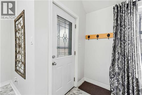 Entryway featuring a white door with decorative glass inserts, light-toned walls, and a patterned curtain - 74 Province Street N, Hamilton, ON - Indoor Photo Showing Other Room