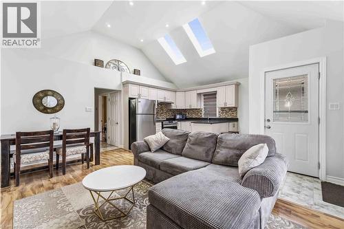 Vaulted ceiling with dual skylights and recessed lighting illuminates this open-concept living space - 74 Province Street N, Hamilton, ON - Indoor Photo Showing Living Room
