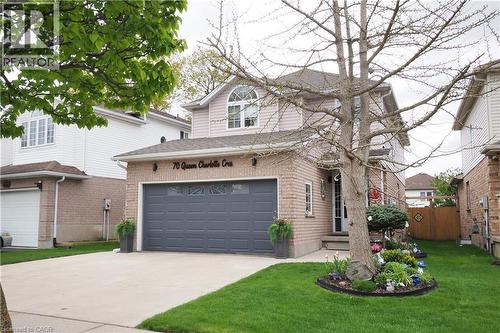 Two-story residential exterior featuring brick and siding construction, an attached two-car garage with transom windows, and a concrete driveway - 70 Queen Charlotte Crescent, Kitchener, ON - Outdoor