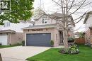 Two-story residential exterior featuring brick and siding construction, an attached two-car garage with transom windows, and a concrete driveway - 70 Queen Charlotte Crescent, Kitchener, ON  - Outdoor 