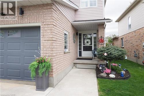 Brick and siding exterior featuring a single-car garage with transom windows - 70 Queen Charlotte Crescent, Kitchener, ON - Outdoor With Exterior