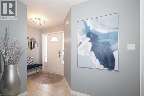 Entryway featuring light-toned tile flooring, a white paneled door with an arched glass insert, and a contemporary ceiling light fixture - 70 Queen Charlotte Crescent, Kitchener, ON - Indoor Photo Showing Other Room