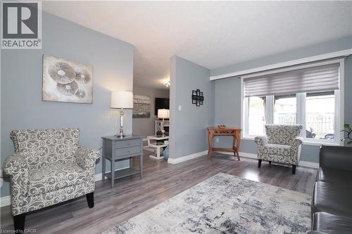 Light gray walls complement the wood-finish flooring in this living area - 70 Queen Charlotte Crescent, Kitchener, ON - Indoor Photo Showing Living Room