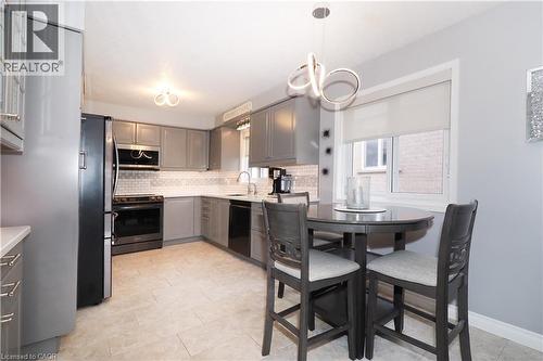Modern kitchen featuring gray cabinetry, light-colored countertops, and subway tile backsplash - 70 Queen Charlotte Crescent, Kitchener, ON - Indoor