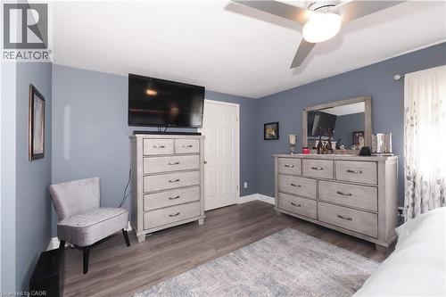 Spacious room featuring wood-finish flooring, a contemporary ceiling fan, and a paneled white door - 70 Queen Charlotte Crescent, Kitchener, ON - Indoor Photo Showing Bedroom