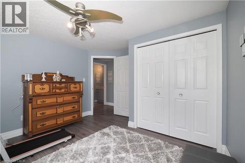 Room featuring wood-finish flooring, light blue wall paint, a textured white ceiling, and a ceiling fan with integrated lighting - 70 Queen Charlotte Crescent, Kitchener, ON - Indoor Photo Showing Bedroom