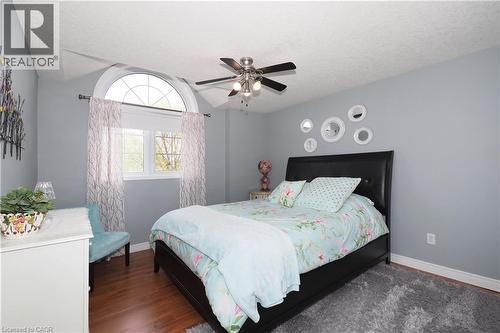 Room featuring a semi-circular transom window, wood-finish flooring, and a ceiling fan with integrated lighting - 70 Queen Charlotte Crescent, Kitchener, ON - Indoor Photo Showing Bedroom