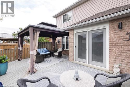 Expansive back deck featuring a gazebo with privacy curtains, a brick exterior, sliding glass doors, and a partial privacy fence - 70 Queen Charlotte Crescent, Kitchener, ON - Outdoor With Deck Patio Veranda With Exterior