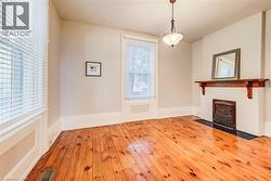 Hardwood flooring complements a decorative fireplace with a wood mantle - 