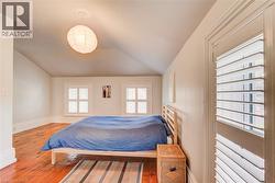 Room featuring warm wood-finish flooring and a sloped ceiling - 