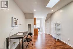 Spacious room featuring wood-finish flooring, recessed lighting, and a skylight - 