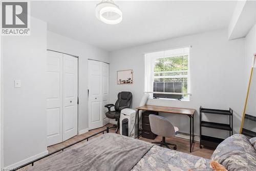 Bright room featuring wood-finish flooring, a contemporary ceiling light fixture, and white bi-fold closet doors - 91 Westmount Road Unit# 3, Waterloo, ON - Indoor