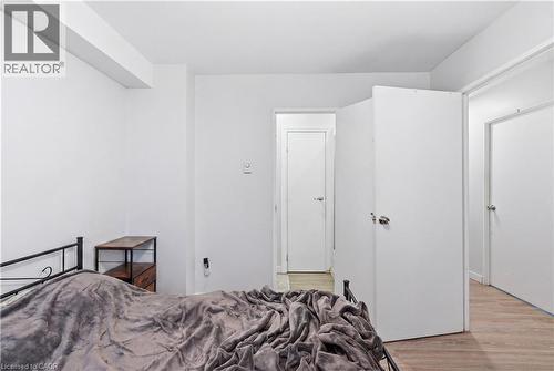 Light wood-finish flooring complements the neutral wall tones - 91 Westmount Road Unit# 3, Waterloo, ON - Indoor Photo Showing Bedroom