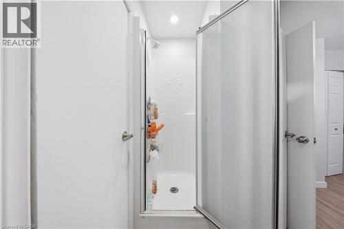 Shower enclosure with a frosted glass door, chrome frame, and a white tub-shower combination - 91 Westmount Road Unit# 3, Waterloo, ON - Indoor Photo Showing Bathroom