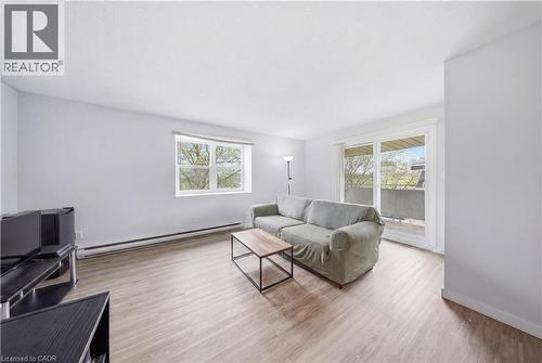 Spacious living area featuring light wood-finish flooring, white walls, and a large window - 91 Westmount Road Unit# 3, Waterloo, ON - Indoor Photo Showing Living Room