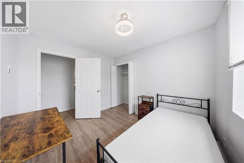 Bright room featuring wood-finish flooring, white paneled doors, and a ceiling-mounted light fixture - 91 Westmount Road Unit# 3, Waterloo, ON - Indoor Photo Showing Bedroom