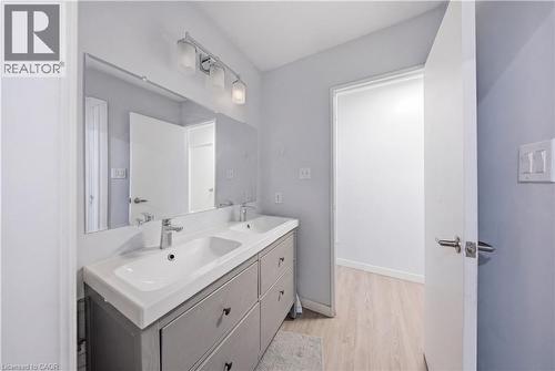 Dual vanity with integrated sinks, chrome faucets, and gray cabinetry - 91 Westmount Road Unit# 3, Waterloo, ON - Indoor Photo Showing Bathroom