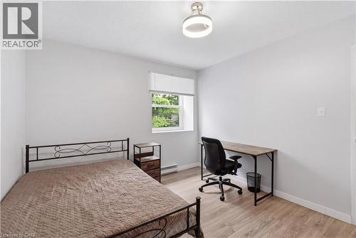 Bright room featuring light wood-finish flooring, a contemporary flush-mount ceiling light, and a window with a white roller blind - 91 Westmount Road Unit# 3, Waterloo, ON - Indoor Photo Showing Other Room