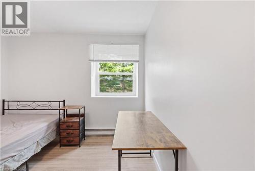 Spacious room featuring light-toned wood-finish flooring, a white window frame, and neutral wall tones - 91 Westmount Road Unit# 3, Waterloo, ON - Indoor Photo Showing Bedroom