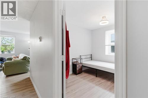 Bright interior space featuring light-toned wood-finish flooring, a white ceiling with a modern flush-mount light fixture, and a window providing natural light - 91 Westmount Road Unit# 3, Waterloo, ON - Indoor Photo Showing Other Room