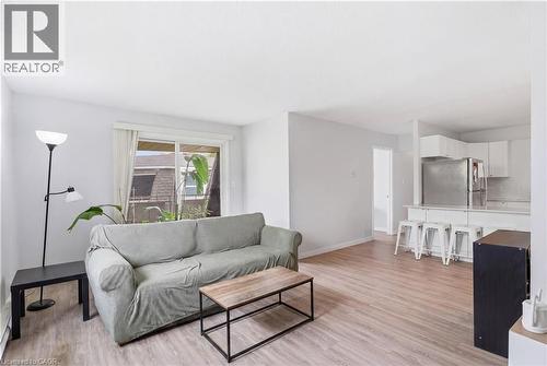 Open-concept living space featuring wood-finish flooring, white walls, and a sliding glass door - 91 Westmount Road Unit# 3, Waterloo, ON - Indoor Photo Showing Living Room