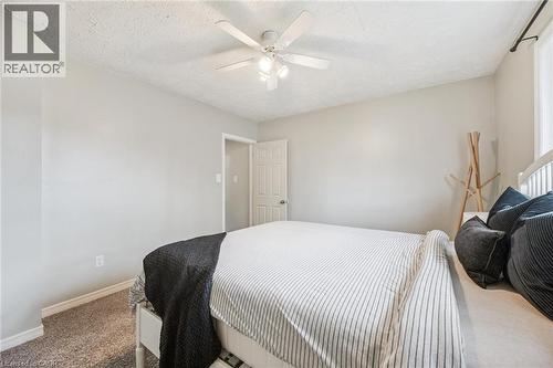 Bedroom featuring neutral wall paint, textured ceiling, a ceiling fan with integrated lighting, window with curtain rod, and carpet flooring - 87 Barbara Crescent, Kitchener, ON - Indoor Photo Showing Bedroom