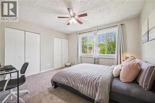 Bedroom featuring multiple bi-fold door closets, a ceiling fan with integrated lighting, and a large window with white trim - 87 Barbara Crescent, Kitchener, ON - Indoor Photo Showing Bedroom
