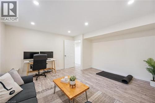 Spacious open-concept room featuring recessed lighting, wood-finish flooring, and crisp white walls - 87 Barbara Crescent, Kitchener, ON - Indoor