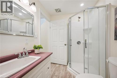 Bathroom featuring a corner glass-enclosed shower, single vanity with a built-in sink, and a framed mirror with overhead lighting - 87 Barbara Crescent, Kitchener, ON - Indoor Photo Showing Bathroom