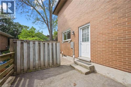 Brick exterior featuring a white door with glass panels, concrete steps, and a side window - 87 Barbara Crescent, Kitchener, ON - Outdoor With Exterior