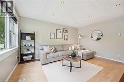 Living area featuring light wood-finish flooring, recessed ceiling lighting, and a large window - 