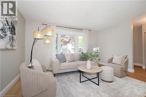 Bright living area featuring a bay window, light wood-finish flooring, and white baseboards - 27 Scenic Wood Crescent, Kitchener, ON - Indoor Photo Showing Living Room