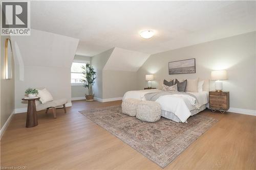 Dormer room featuring wood-finish flooring, light-toned wall paint, white baseboards, and a single window - 27 Scenic Wood Crescent, Kitchener, ON - Indoor Photo Showing Bedroom